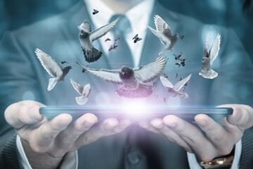 A businessman shows a tablet with doves flying out of it .