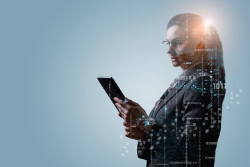 A woman in a business suit works on a tablet with binary codes .