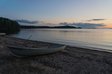 Seascape and a boat on the shore. Peaceful, calm, evening sky and sea. Natural background. Summer evening.
