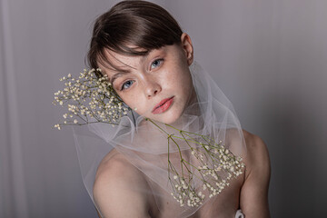 Ritratto di giovane ragazza con fiori bianchi e tulle
