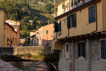 Fototapeta na wymiar Italian style apartments next to a river. Old city of Carrara, Toscana.