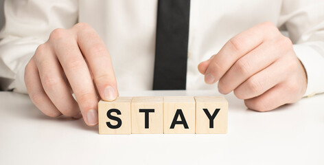 The wooden blocks say STAY . Concept image a wooden block and word - STAY
