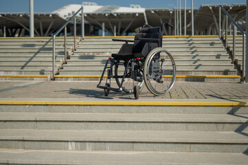 Abandoned wheelchair by the stairs. Hard to access environment. 