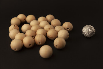 wooden balls and silver ball on black background