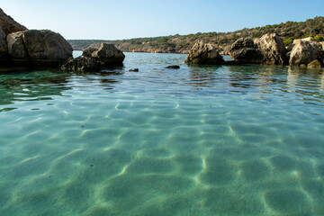 Crystal clear blue water of Mediterranean sea  and yellow rocks in on Konnos beach near Protaras, Cyprus
