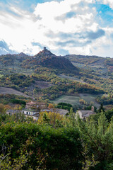 Fototapeta na wymiar Hiking on hills near Bagno Vignoni and view on Rocco Tuscany, Italy. Tuscan landscape with cypress trees, vineyards, forests and ploughed fields in autumn.