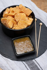 Cheese tasting, small pieces of old Dutch hard cheese and bowl with homemade dill-mustard sauce