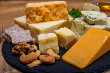 British drinks and food, glasses of Scotch whisky and cheeses collection, blue Stilton, Scottish coloured and English matured cheddar cheeses