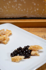 Tasting of 72 months very old Italian parmigiano-reggiano parmesan cheese from Parma  with extremely grainy with black pearls of balsamic vinegar DOP from Modena.