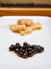 Tasting of 72 months very old Italian parmigiano-reggiano parmesan cheese from Parma  with extremely grainy with black pearls of balsamic vinegar DOP from Modena.