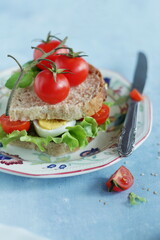 Sandwich with tomato, egg and green lettuce, simple home eating concept.