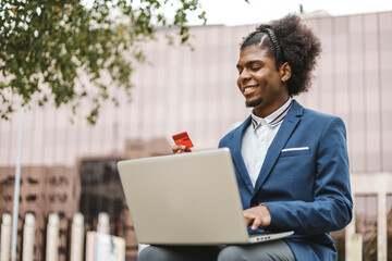 smiling afro businessman using shopping online with credit card