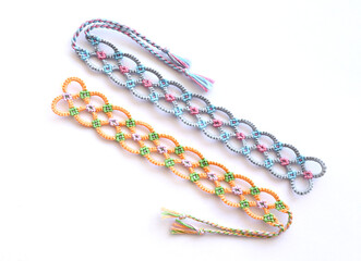 Woven DIY friendship bracelets handmade of embroidery bright thread with knots on white background