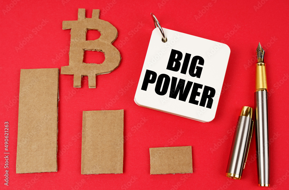 Aufkleber on a red surface lie the bitcoin symbol, a pen and a notepad with the inscription - big power