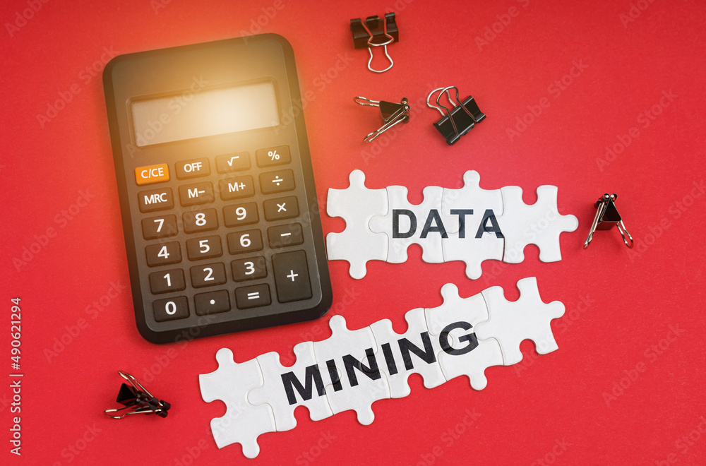 Poster on the red surface are a calculator, clamps and puzzles with the inscription - data mining
