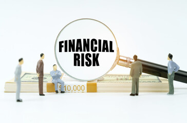 Fototapeta premium On a white surface, a dollar, figurines of people and a magnifying glass with the inscription - financial risk