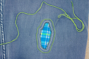 Visible mending on jeans, creative sustainable fashion, repair, mend and recycle. slow fashion make...
