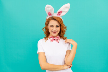 happy winking easter girl in bunny ears and bow tie on blue background