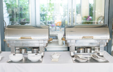 Buffet Table with Row of Food Service Steam Pans in the restaurant hotel for guests to eat at the hotel.