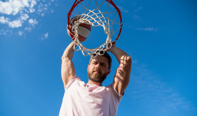 Fototapeta na wymiar bearded man player throw basketball ball through basket, sport hobby