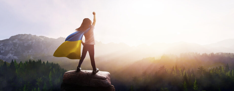 girl with a cape of the flag of ukraine - concept of peace and freedom