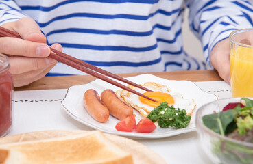 Obraz na płótnie Canvas 半熟目玉焼きを食べるアジア人の男性