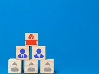 People icons on wooden cubes. Leadership and company hierarchy concept.