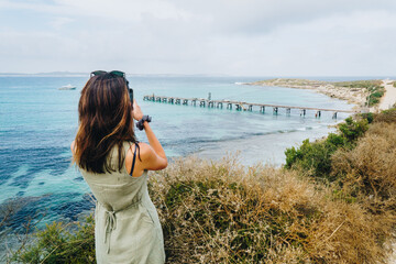 Fototapeta na wymiar Woman taking photo of Vivonne Bay Jetty on kangaroo Island, South Australia