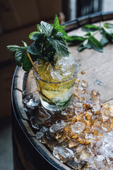 Making a Mint Julep cocktail with crushed ice, fresh mint, bourbon whiskey - obrazy, fototapety, plakaty