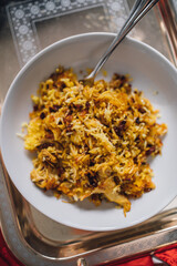 Persian Saffron Barberry Rice with Chicken single serving on white dish (Zereshk Polo ba morgh Irani)