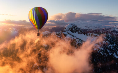 Dramatic Mountain Landscape covered in clouds and Hot Air Balloon Flying. 3d Rendering Adventure Dream Concept Artwork. Aerial Image from British Columbia, Canada. Colorful Sunset Sky
