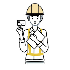 立って書類とカードを手に持つ工事現場の女性