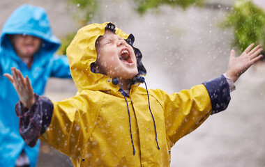 They love the rain. Shot of a young brother and sister playing in the rain.