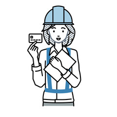立って書類とカードを手に持つ工事現場の女性