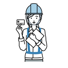 Obraz premium 立って書類とカードを手に持つ工事現場の女性