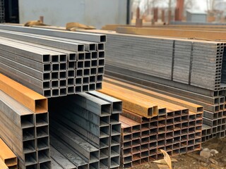 Steel iron materials, building materials. Coated profiles in rack. Metal profile pipe of rectangular section in packs in a warehouse.