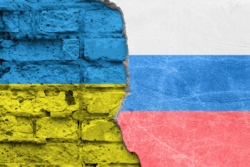 Old brick wall with flags of Ukraine and Russia on a split background