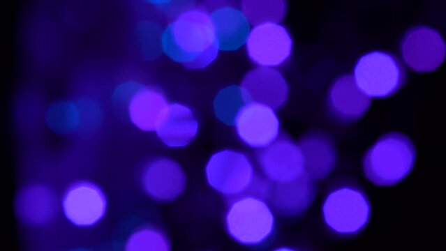 Very peri purple blue lights and bokeh. Neon lights on a dark background move and flicker
