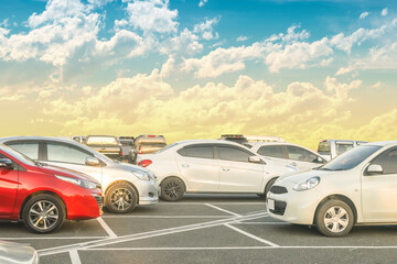 Fototapeta na wymiar Car parked in large asphalt parking lot with beautiful cloud and sunset sky background
