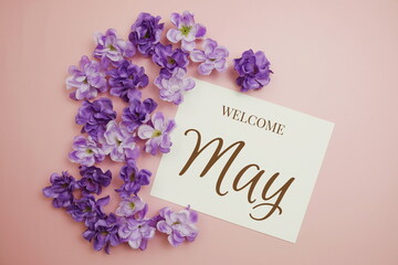 Welcome May card typography text with flower bouquet on pink background