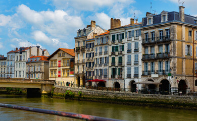 Fototapeta na wymiar Cityscape of French city Bayonne with embankment of Nive river