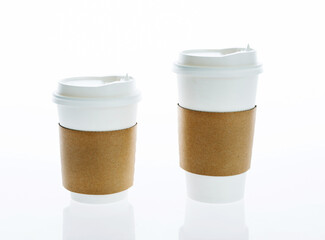 Two take away paper cups with closed caps against white background