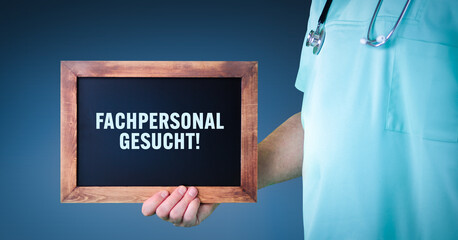 Fachpersonal gesucht! (Arztpraxis). Arzt zeigt Schild/Tafel mit Holz Rahmen. Hintergrund blau