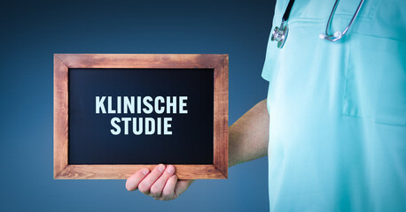 Klinische Studie. Arzt zeigt Schild/Tafel mit Holz Rahmen. Hintergrund blau