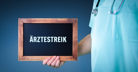 Ärztestreik. Arzt zeigt Schild/Tafel mit Holz Rahmen. Hintergrund blau