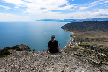 A girl on the background of landscapes of the Black Sea and the Crimean mountains on the Golitsyn trail. Crimea. 2021