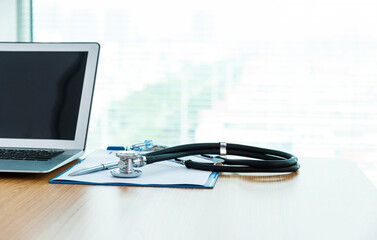 Obraz na płótnie Canvas Stethoscope, pen, laptop and blank prescription form on doctor working table