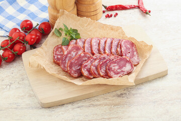 Sliced salami sausages over board
