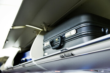 Suitcase on the top shelf of airplane