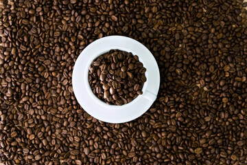 Coffee beans in cup and on table for background